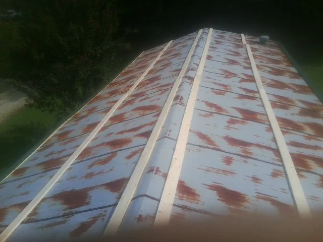 Rusted metal roof panels with new wood purlins before replacement — Storm Damage Roof Repair in Genesee by Roofing Brothers